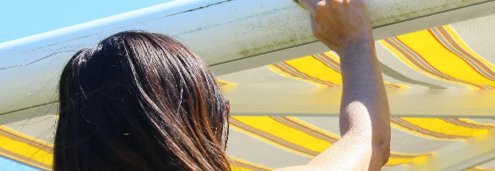 Person reinigt Markise mit Tuch